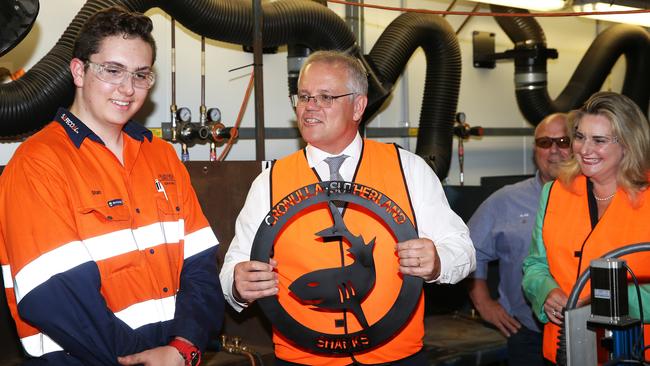 Apprentices give Prime Minister Scott Morrison, centre, a Cronulla Sharks trophy they made out of metal at the HVTC Training Company at Rutherford in the NSW Hunter Valley on Monday. Picture: Peter Lorimer