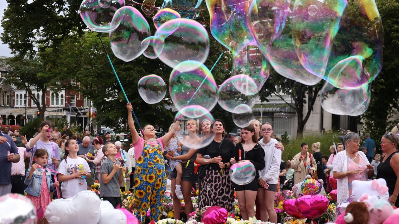 People make bubbles as they gather to mourn the three victims of a knife attack in Southport. Picture: Dan Kitwood/Getty Images)