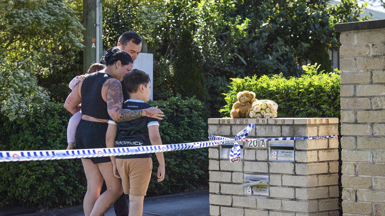 Neighbours leave flowers and a teddy at the scene of the triple fatal house fire in Harristown on Thursday morning. Picture: Kevin Farmer