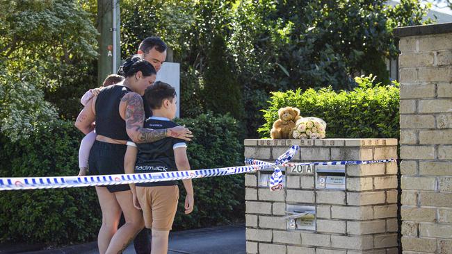 Neighbours leave flowers and a teddy at the scene of the triple fatal house fire in Harristown on Thursday morning. Picture: Kevin Farmer