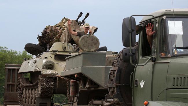 Ukrainian servicemen greet people as they ride through the eastern region of Donetsk on Tuesday. Picture: AFP