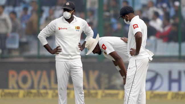 Sri Lanka's Suranga Lakmal (C) vomits as his teammates stand next to him.