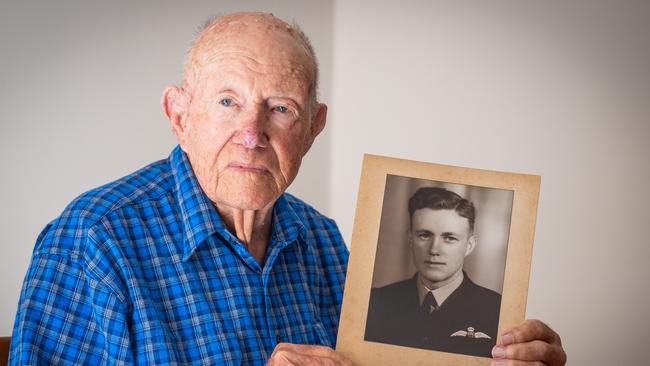 Bill Purdy, a 100-year-old veteran, at his home in Mosman, Sydney, with a picture of him in uniform from 1944. Picture: Renee Nowytarger