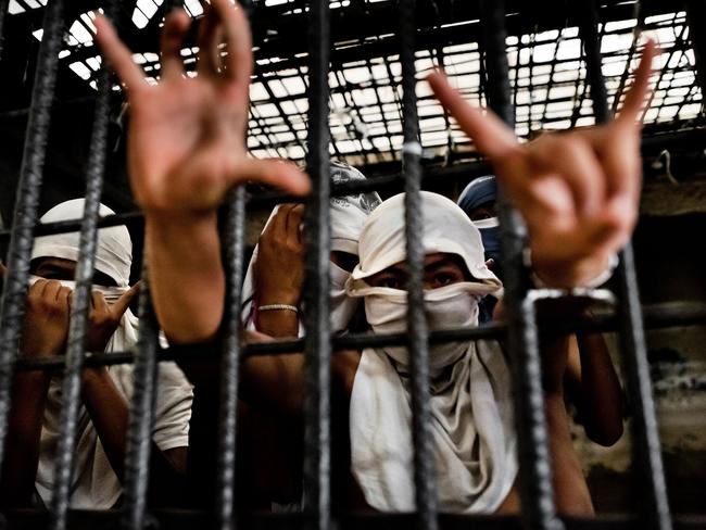 MS13 gang members, who use the death’s head hand signal, are housed separately to their rival Barrio 18 members in Salvadorean prisons. Picture: Jan Sochor/Rex Features.