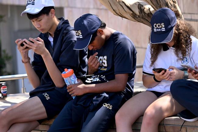 Students look at their phones in Australia, where the government has passed a law banning social media for those under 16