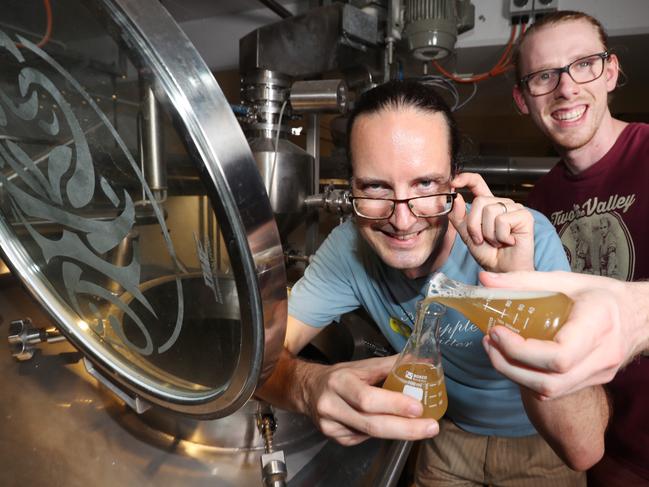 University of Queensland scientists Dr Ben Schulz and Edward Kerr with beakers of beer. At Newstead Brewing Co's Pic  Annette Dew