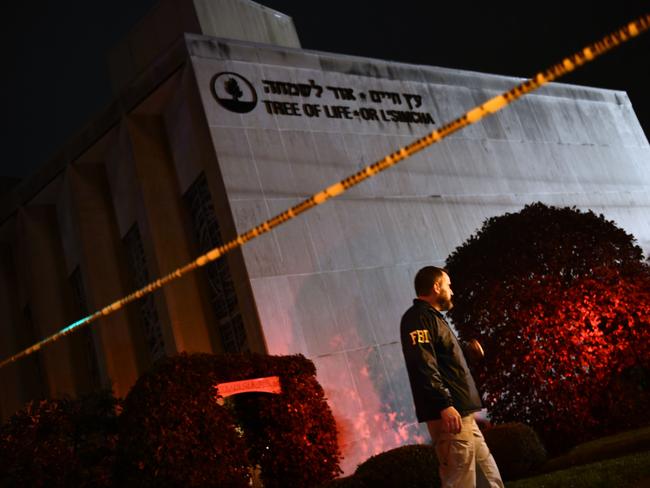 TOPSHOT - An FBI agent stands behind a police cordon outside the Tree of Life Synagogue after a shooting there left 11 people dead in the Squirrel Hill neighborhood of Pittsburgh on October 27, 2018. - A heavily armed gunman opened fire during a baby-naming ceremony at a synagogue in the US city of Pittsburgh on October 27, killing 11 people and injuring six in the deadliest anti-Semitic attack in recent American history. (Photo by Brendan Smialowski / AFP)