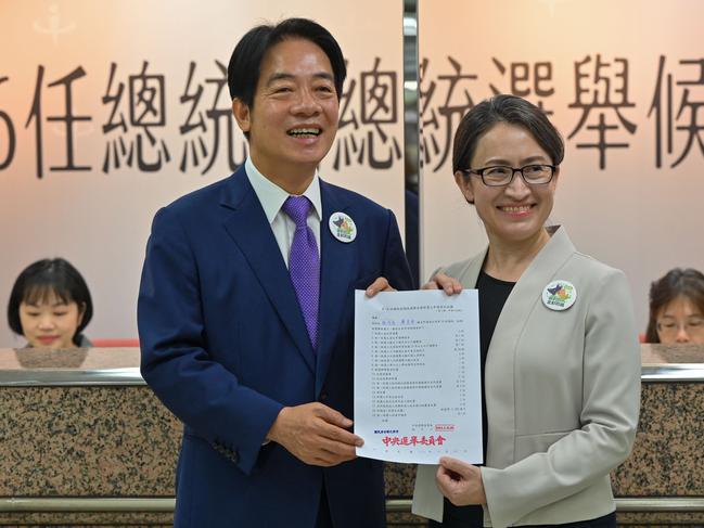 Taiwan presidential candidate Lai Ching-te (L) and his running mate Hsiao Bi-khim (R) , from the ruling Democratic Progressive Party (DPP), display a document at the Central Elections Committee after they registered running for the 2024 presidential elections in Taipei on November 21, 2023. (Photo by Sam Yeh / AFP)