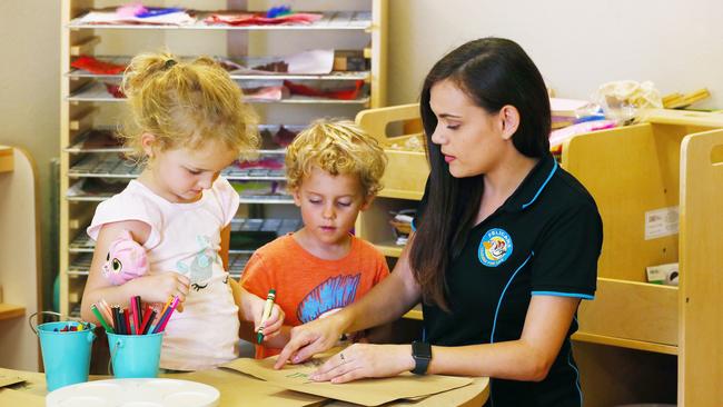 Evelyn Cahill, 4, and Taylor Greenwood, 3, create some artworks with the help of child care educator Ashleigh Turpin at Pelicans child care centre. PICTURE: BRENDAN RADKE