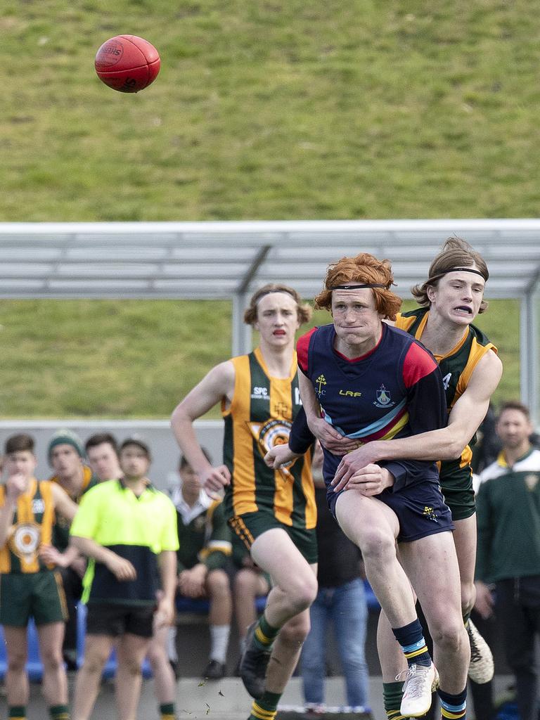 Guilford Young College’s Dom White gets his kick away as St Patrick’s College’s Bailey Gillow tackles. Picture: Chris Kidd