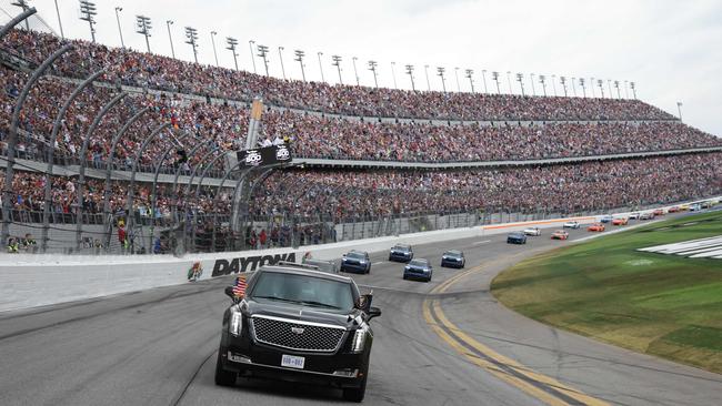 Donald Trump rides in the presidential limousine during a pace lap ahead of the start of the Daytona 500. Picture: AFP