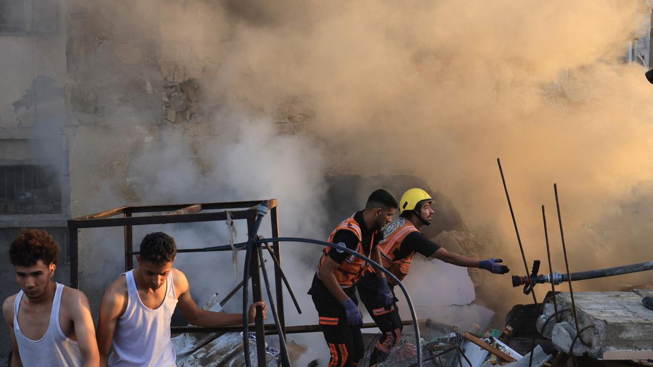 Smoke billows as Palestinian rescuers are at a collapsed building following a strike by the Israeli military on Khan Yunis in the southern Gaza Strip. Picture: AFP