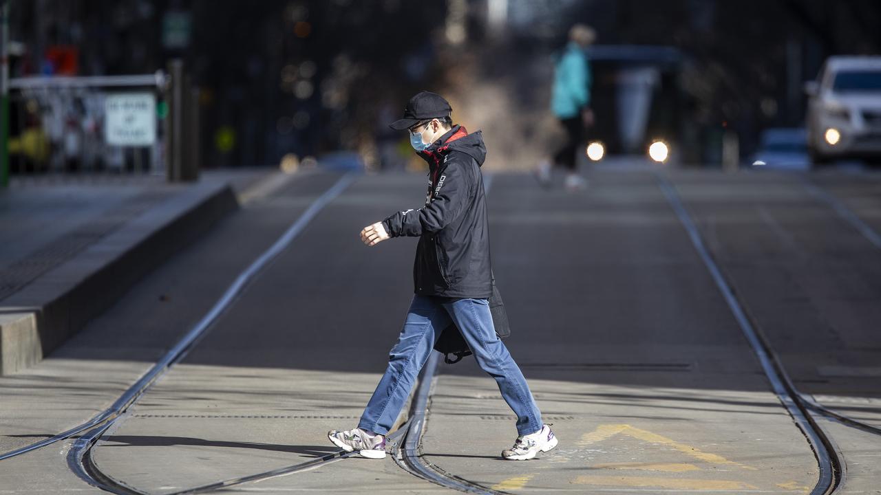 A lone pedestrian crosses the usually bustling Collins St in Melbourne on Thursday. Picture: NCA NewsWire / Sarah Matray