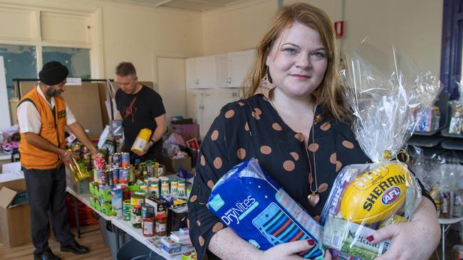 Kate Leaney, campaigns and communications manager for Welcoming Australia, helps pack Australian and Afghan donated goods to new arrivals pat the Welcoming Centre in Bowden.