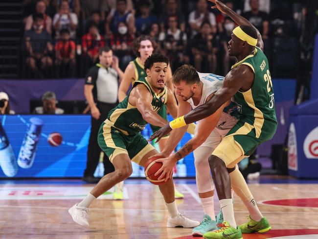 Josh Green #6 and Duop Reath #26 battle it out with Luka Doncic. Picture: Takashi Aoyama/Getty Images