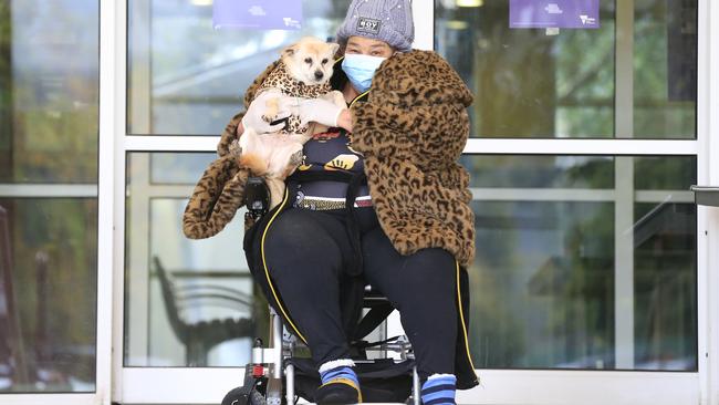 A Flemington tower resident takes her dog outside on Friday morning. Picture: Darrian Traynor/Getty Images