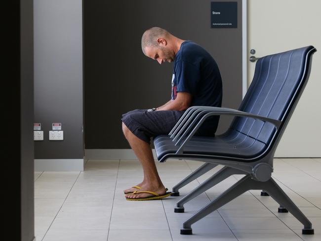 Chris Lavery sits handcuffed at Cairns Airport waiting to be extradited to Victoria. Picture: Marc McCormack