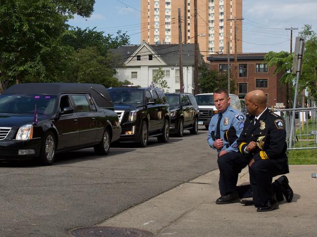 Minneapolis Police Chief Medaria Arradondo (right) knelt as the body of George Floyd was taken to a memorial service held in his honour. Picture: AFP