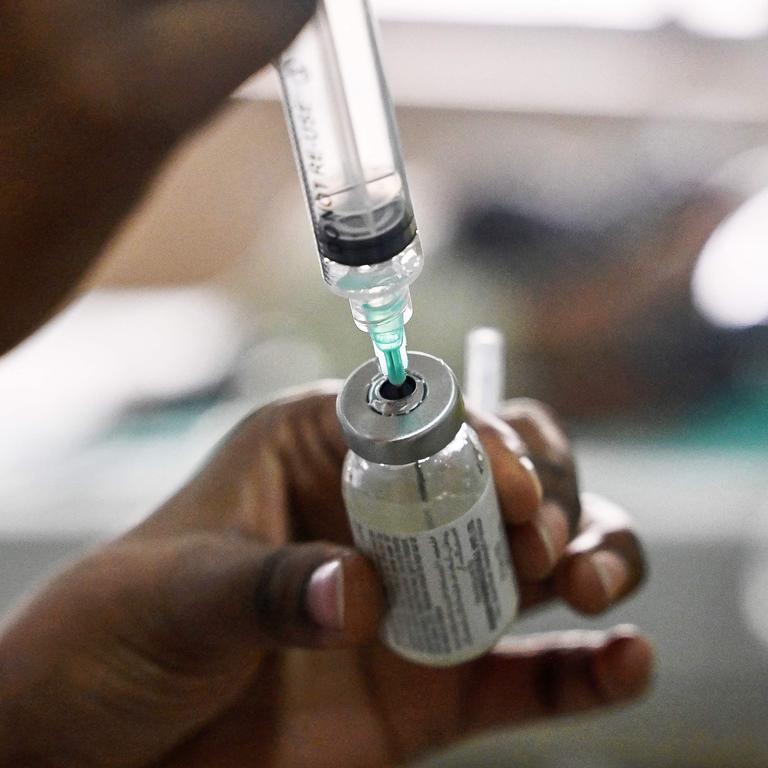 A nurse prepares a pneumonia vaccine to treat a child suffering from the disease.