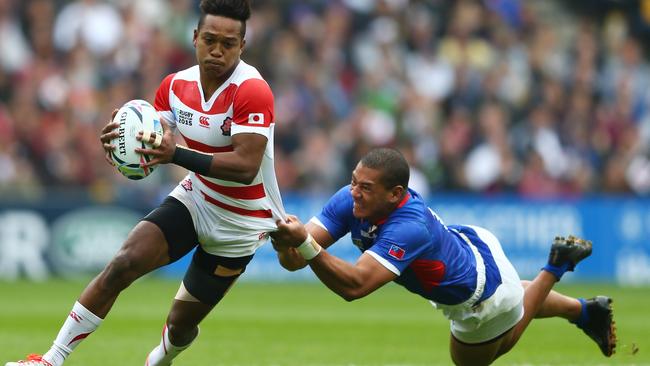 Kotaro Matsushima of Japan is tackled by Paul Perez of Samoa.