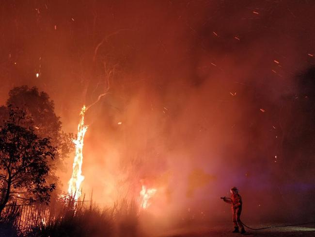 A supplied image obtained Tuesday, September 10, 2019 of firefighters battling a bushfire in Peregian Springs on the Sunshine Coast, Monday, September 9, 2019. (AAP Image/John Park) NO ARCHIVING, EDITORIAL USE ONLY