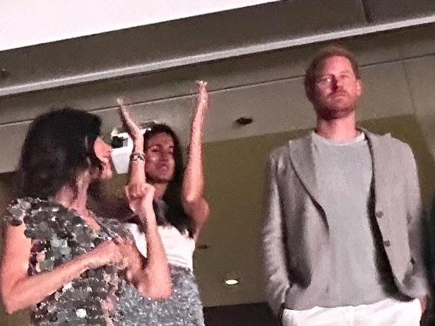 Prince Harry looks glum while Meghan Markle and her mum dance up a storm at the Beyonce concert in LA.