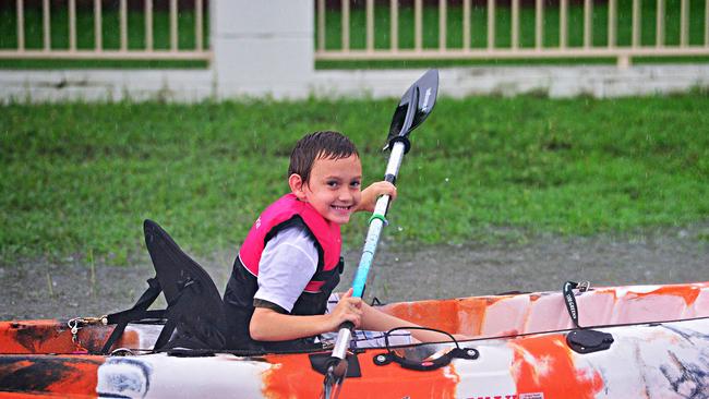 Townsville suburbs were flooded after more than 400mm of rain smashed the northern city this week. Jaxzyn Oliver-Hardy, 6, paddles on a kayak in the suburb of Deeragun. Picture: Zak Simmonds