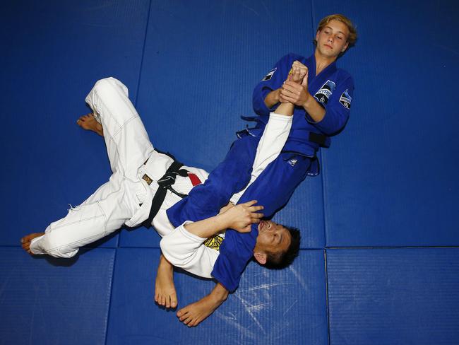 Khava Black (in blue) grapples with one of his coaches Owen Gee Kee at Sydney Gracie Barra in Alexandria. Picture: John Appleyard