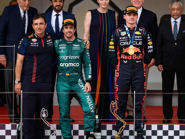 Winner Red Bull Racing's Dutch driver Max Verstappen (C), second-placed Aston Martin's Spanish driver Fernando Alonso (2nd L) and third-placed Alpine's French driver Esteban Ocon (R) pose flanekd by Princess Charlene of Monaco (C-L), and  Prince Albert II of Monaco (C-R) on the podium  after the Formula One Monaco Grand Prix at the Monaco street circuit in Monaco, on May 28, 2023. (Photo by Jeff PACHOUD / AFP)