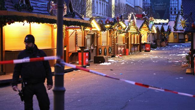 A policeman walks through the shuttered Christmas market, a day after the attack that has left five people dead, including a small child, and over 200 injured. Picture: Getty