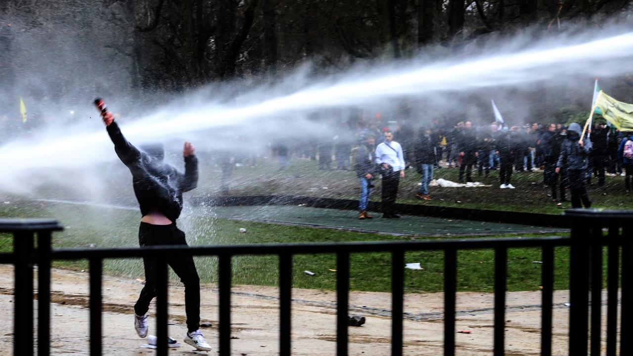 A demonstrator is sprayed with water cannons while clashing with police in Belgium. Picture: Valeria Mongelli/Bloomberg via Getty Images