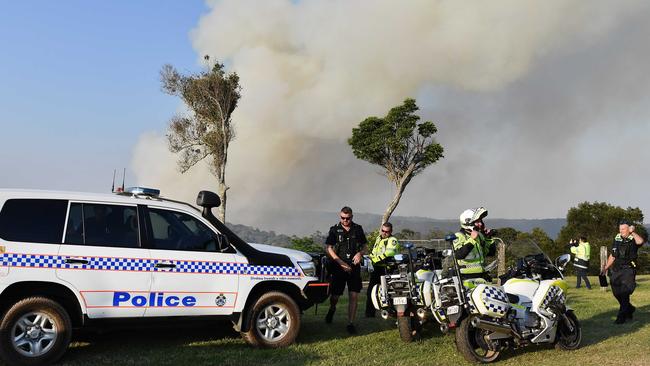 Police at Schultz Rd, near Obi Obi, on October 31, with the fire in the background. Picture: Patrick Woods.