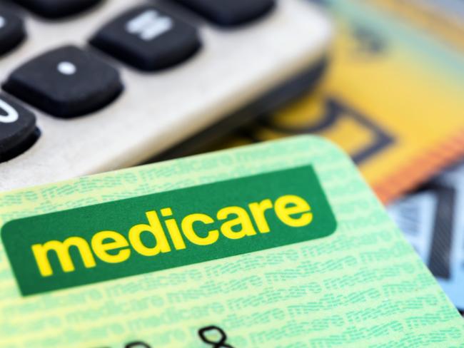 Australian Medicare card with calculator and cash background.