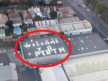 An eagle-eyed passenger on board a flight in to Sydney has snapped an unusual rooftop sign he noticed as the plane descended to the runway.
