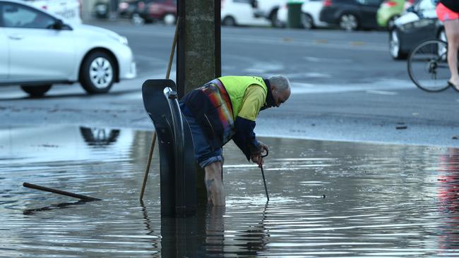 A burst water main in Jeffcott St, North Adelaide, saw water come very close to houses. Adelaide City Council workers clear the drains. Picture: Tait Schmaal.