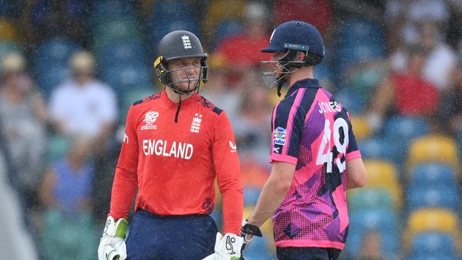 Jos Buttler of England and Michael Jones of Scotland leave the field as rain stops play. Picture: Gareth Copley/Getty Images