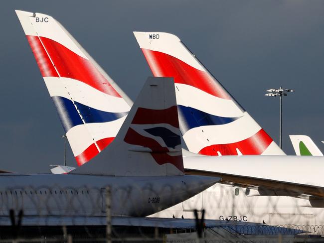 Sunlight illuminates the tailfins of British Airways aircraft at Terminal 5 of London Heathrow Airport in west London on February 5, 2021. - Britain confirmed Thursday it will introduce its new mandatory hotel quarantine rules for travellers returning from dozens of countries deemed at 