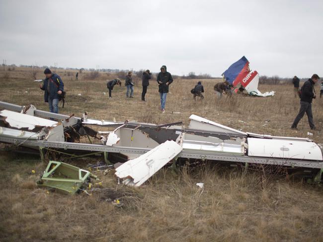 (FILES) In this file photo taken on November 11, 2014 Journalists look at parts of the Malaysia Airlines plane Flight MH17 as Dutch investigators (unseen) arrive at the crash site near the Grabove village in eastern Ukraine, hoping to recover debris from the Malaysia Airlines plane which crashed in July, killing 298 people, in remote rebel-held territory east of Donetsk. - A Dutch court gives its verdict on November 17, 2022 in the trial of four men over the downing of Malaysia Airlines flight MH17 above Ukraine in 2014, as tensions soar over Russia's invasion eight years later. All 298 passengers and crew were killed when the Boeing 777 flying from Amsterdam to Kuala Lumpur was hit over separatist-held eastern Ukraine by what investigators say was a missile supplied by Moscow. (Photo by Menahem KAHANA / AFP)