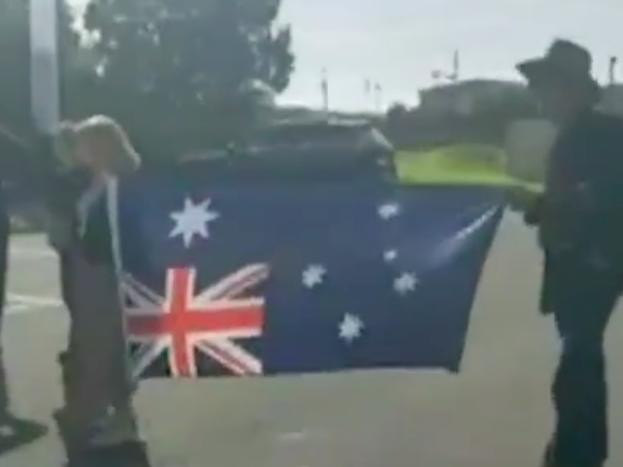 Protesters hold an Australian flag upside down in Trafalgar on the weekend. Picture: 7 News