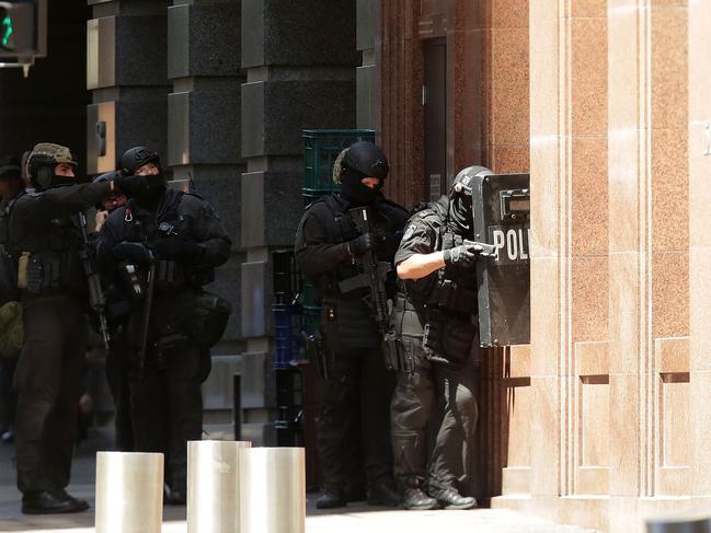 Police attemptd to peer through a window earlier on in the Martin Place siege. Picture: Mark Metcalfe