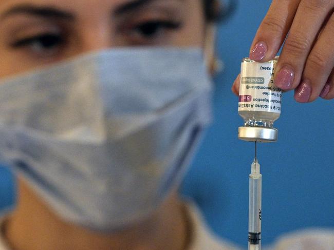 A member of the Armed Forces prepares a dose to vaccinate colleagues against the novel coronavirus COVID-19 with the AstraZeneca/Oxford vaccine obtained through the Covax scheme, at the CCK Cultural Centre in Buenos Aires on June 15, 2021. (Photo by Juan MABROMATA / AFP)