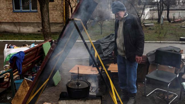 A man cooks outside his house in Bucha. Picture: AFP