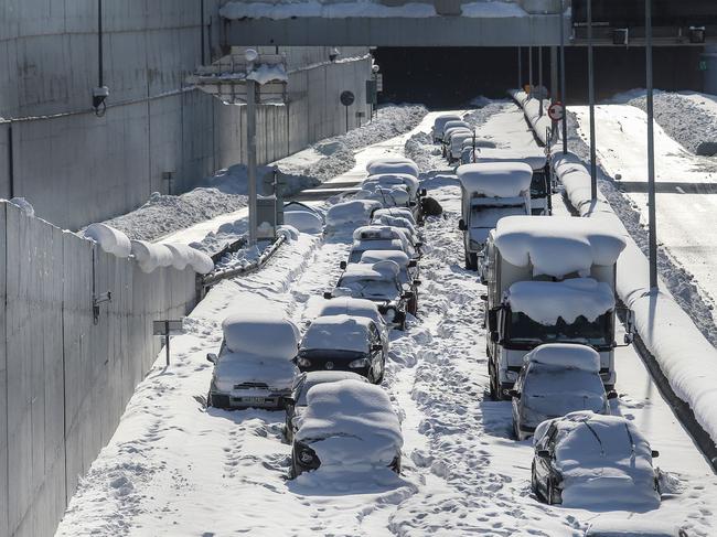 TOPSHOT - Cars are abandoned after being immobilized at Attiki Odos, Athens main ring road, early on January 25, 2022 following a heavy snowfall in Athens. (Photo by Sotiris DIMITROPOULOS / Eurokinissi / AFP)