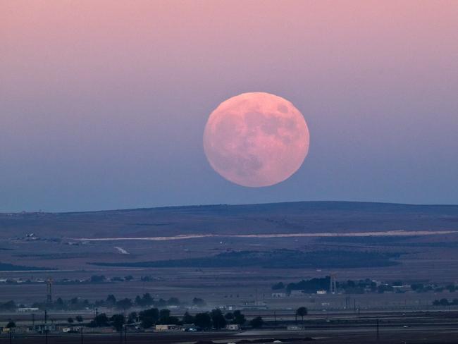 Under seige...a full moon rises seen from a hilltop overlooking Kobane, which has been under assault by extremists of the Islamic State since mid-September, and is being defended by Kurdish fighters. Picture: AP