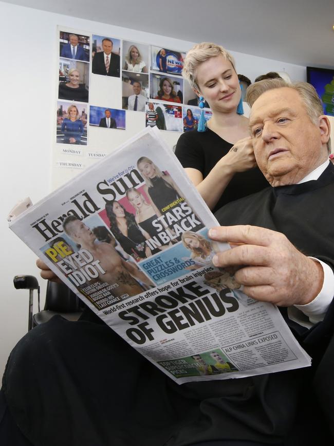 Peter Hitchener reads the paper while having his hair and make-up done. Picture: David Caird