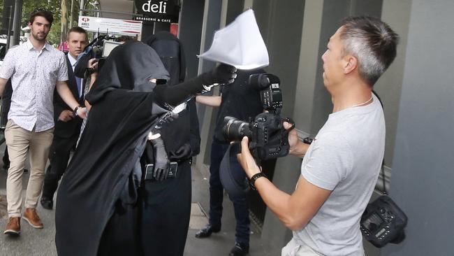 Supporters of one of the accused men clash with a photographer outside court. Picture: David Caird