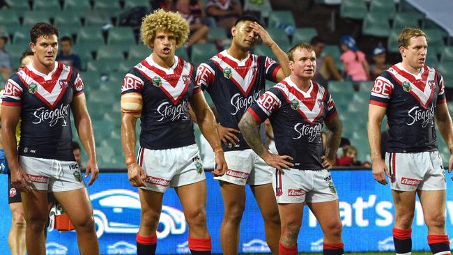 Dejected Roosters players look on after conceding a try.