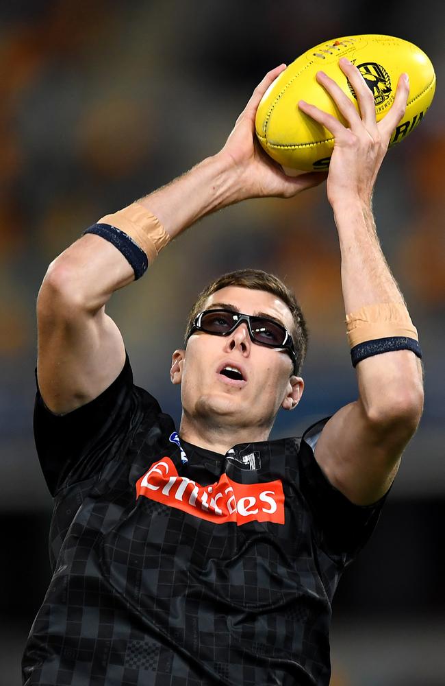 Mason Cox of the Magpies warms up