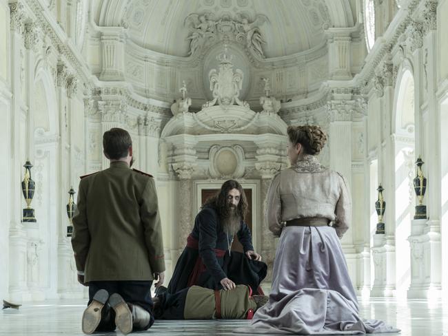 Rhys Ifans as Rasputin (facing camera), Alexander Shefler as Tsaravich Alexei (on floor), Tom Hollander as Tsar Nicholas (left back to camera), Branka Katic as Tsarina Alix (right back to camera) in 20th Century Studios’ THE KING’S MAN. Photo credit: Peter Mountain. © 2020 Twentieth Century Fox Film Corporation. All Rights Reserved.