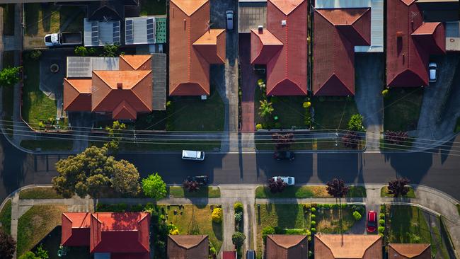 Flying over the suburbs of Melbourne; Community; Housing Development; Railroad Crossing; Crossing; Urban Scene; Aerial View; High Angle View; Melbourne - Australia; Roof; Street; Suburb; Residential District; City; Aerial Photograph. For group read story on rooming house laws. iSTOCK